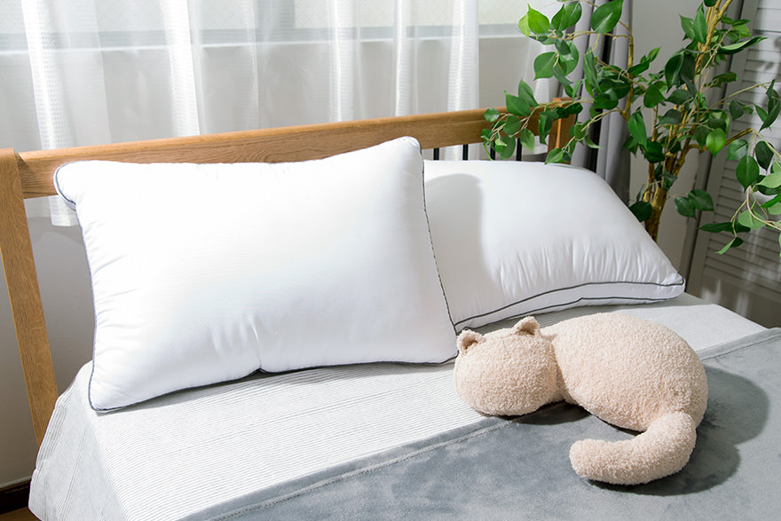 ベッドの上に置いたミャウマミー（ベージュ）